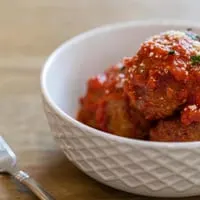 Close-up of Rig A' Tony's Italian meatballs in red sauce, topped with parmesan and parsley.